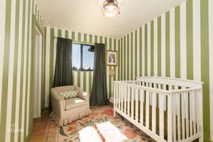 Bedroom featuring a crib and wood finished floors