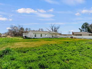 Rear view of house with a partial fenced backyard