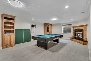 Recreation room featuring crown molding, carpet, a premium fireplace, billiards table, and recessed lighting