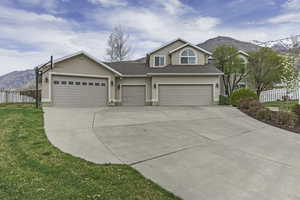 View of front facade with a mountain view, stucco siding, driveway, a garage, and roof with shingles