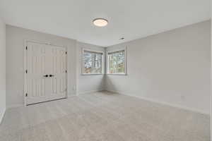 3rd Bedroom with light colored carpet and a closet