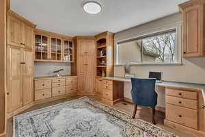 Office with built in study area and light wood-style floors