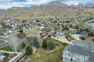 Aerial view of property and surrounding area with a mountainous background and nearby suburban area