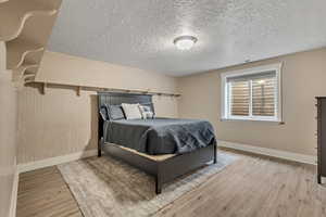 6th Bedroom with a textured ceiling and light wood-type flooring