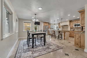 Dining room featuring a textured ceiling and a chandelier