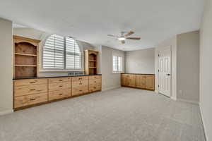 5th Bedroom or recreation room featuring light colored carpet, a ceiling fan, and a textured ceiling