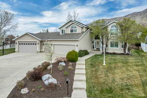 Traditional-style home featuring roof with shingles, stucco siding, driveway, and an attached garage