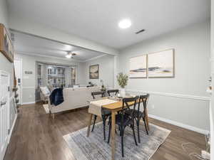 Dining area featuring ceiling fan, dark wood-type flooring, and crown molding