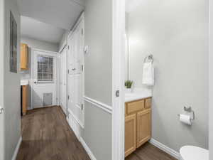 Bathroom with vanity, dark wood finished floors, and electric panel