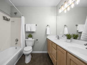 Bathroom featuring double vanity and shower / tub combo with curtain