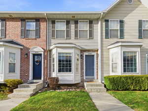 Colonial-style house featuring brick siding and a front yard