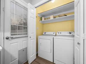 Laundry area featuring dark wood finished floors and washing machine and clothes dryer