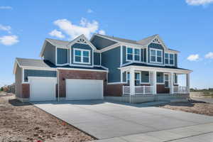 Craftsman-style home featuring driveway, a porch, brick siding, a garage, and a shingled roof