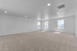 Spare room with light colored carpet, recessed lighting, and a textured ceiling