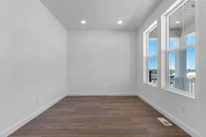 Unfurnished room with dark wood-type flooring and recessed lighting