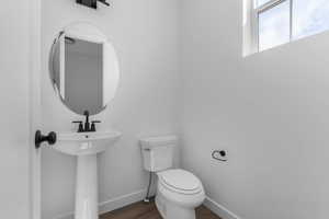 Bathroom featuring toilet and dark wood-style flooring