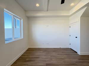 Unfurnished room featuring beamed ceiling, recessed lighting, dark wood finished floors, and a ceiling fan
