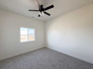 Empty room featuring carpet and ceiling fan