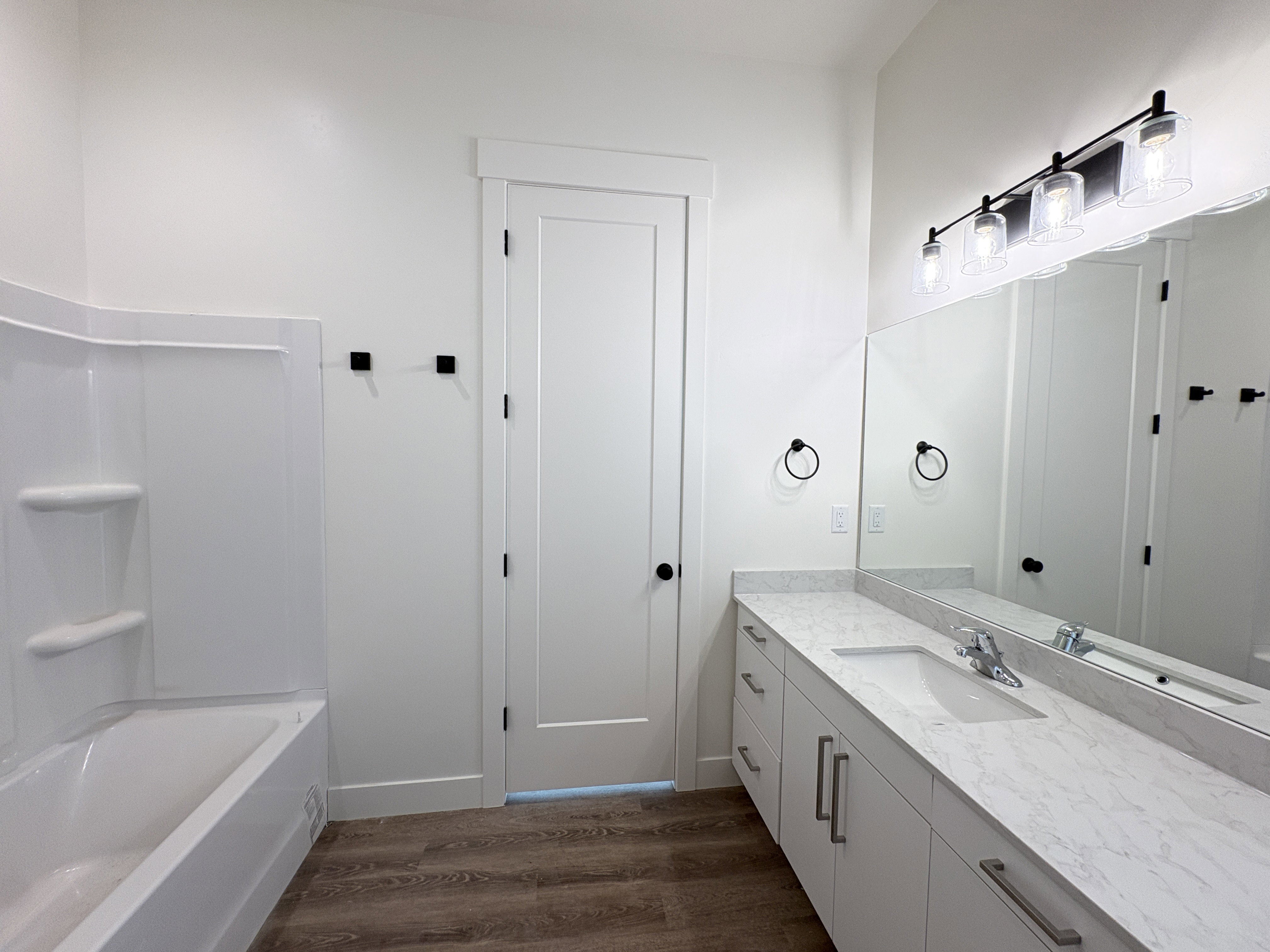 Bathroom with vanity, dark wood finished floors, and tub / shower combination