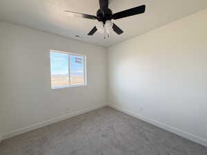 Unfurnished room featuring carpet and ceiling fan