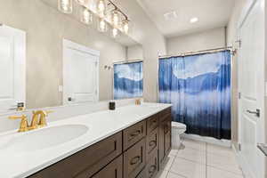 Full bathroom featuring double vanity and light tile patterned flooring