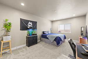 Bedroom featuring an office area, light colored carpet, and recessed lighting