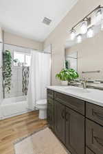 Bathroom with light wood-type flooring, vanity, and shower / bath combo