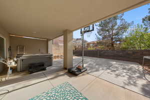 Fenced backyard featuring a patio area and a hot tub