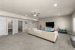 Living room featuring ceiling fan, light carpet, and recessed lighting