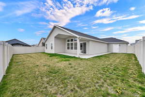 Back of property with stucco siding, a fenced backyard, a patio area, and roof with shingles