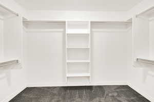 Walk in closet featuring dark colored carpet