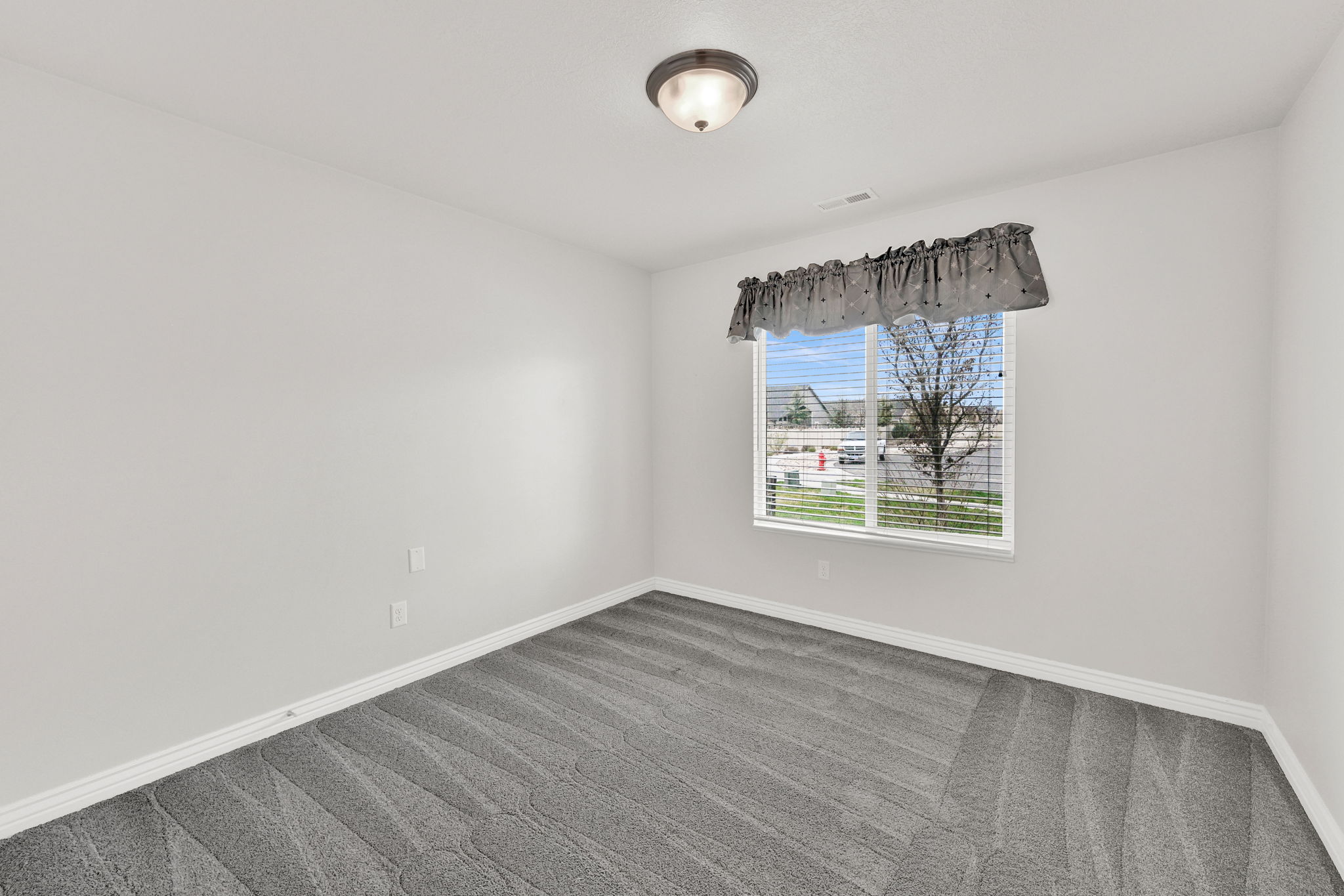 Spare room with dark colored carpet and baseboards