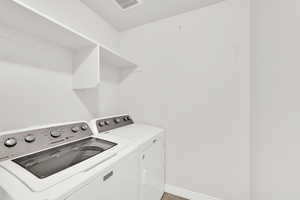 Laundry room featuring baseboards and washer and clothes dryer