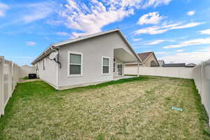 Back of property with a fenced backyard, stucco siding, and a patio