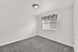 Unfurnished room with carpet floors and baseboards