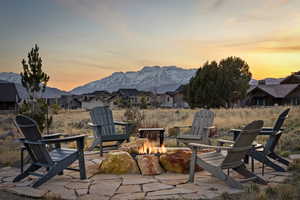 Patio terrace at dusk featuring a fire pit, a patio, a mountain view, and a residential view
