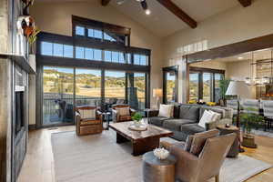 Living area featuring light wood-style floors, a fireplace, hanging lights, and a ceiling fan