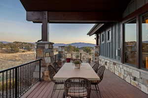 Deck at dusk with outdoor dining area and a mountain view