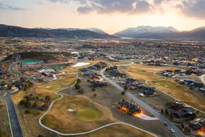 Aerial view at dusk of a mountain view, view of golf course, and a residential view