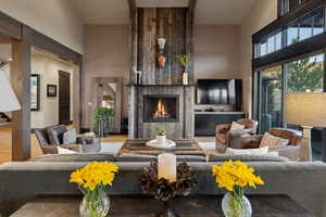 Living area featuring a large fireplace, wood finished floors, and lofted ceiling