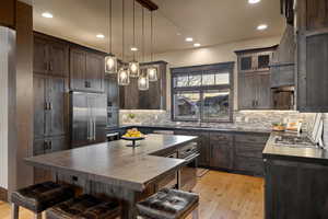 Kitchen with dark wood finish cabinets, light wood-type flooring, and stainless steel appliances