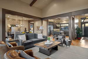 Living area with a chandelier, light wood-style floors, and vaulted ceiling