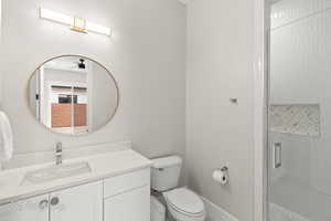 Bathroom featuring vanity, a shower stall, and ceiling fan