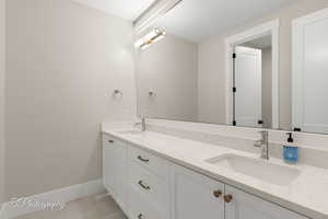 Full bathroom featuring double vanity and light tile patterned flooring