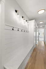 Mudroom featuring light wood-style floors and baseboards
