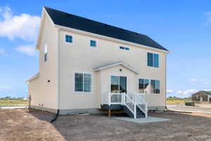 Two-story stucco residence featuring a dark shingle roof and multiple windows