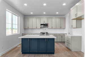Modern kitchen featuring a blue island with a white countertop
