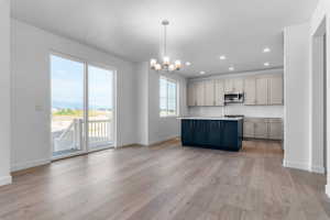 Open-concept living space featuring wood-finish flooring, a contemporary kitchen, and sliding glass doors