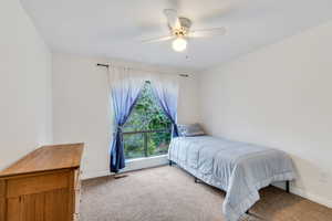 Bedroom featuring a ceiling fan and light colored carpet