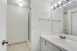 Full bathroom with vanity and a shower stall